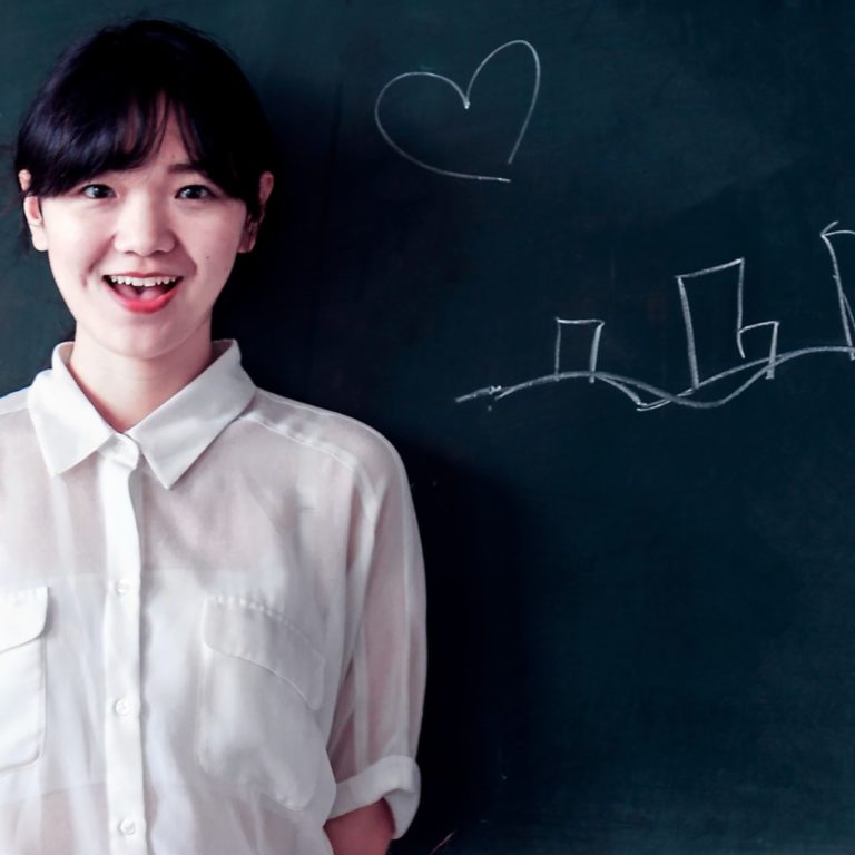 woman-stands-behind-green-concrete-wall-734168